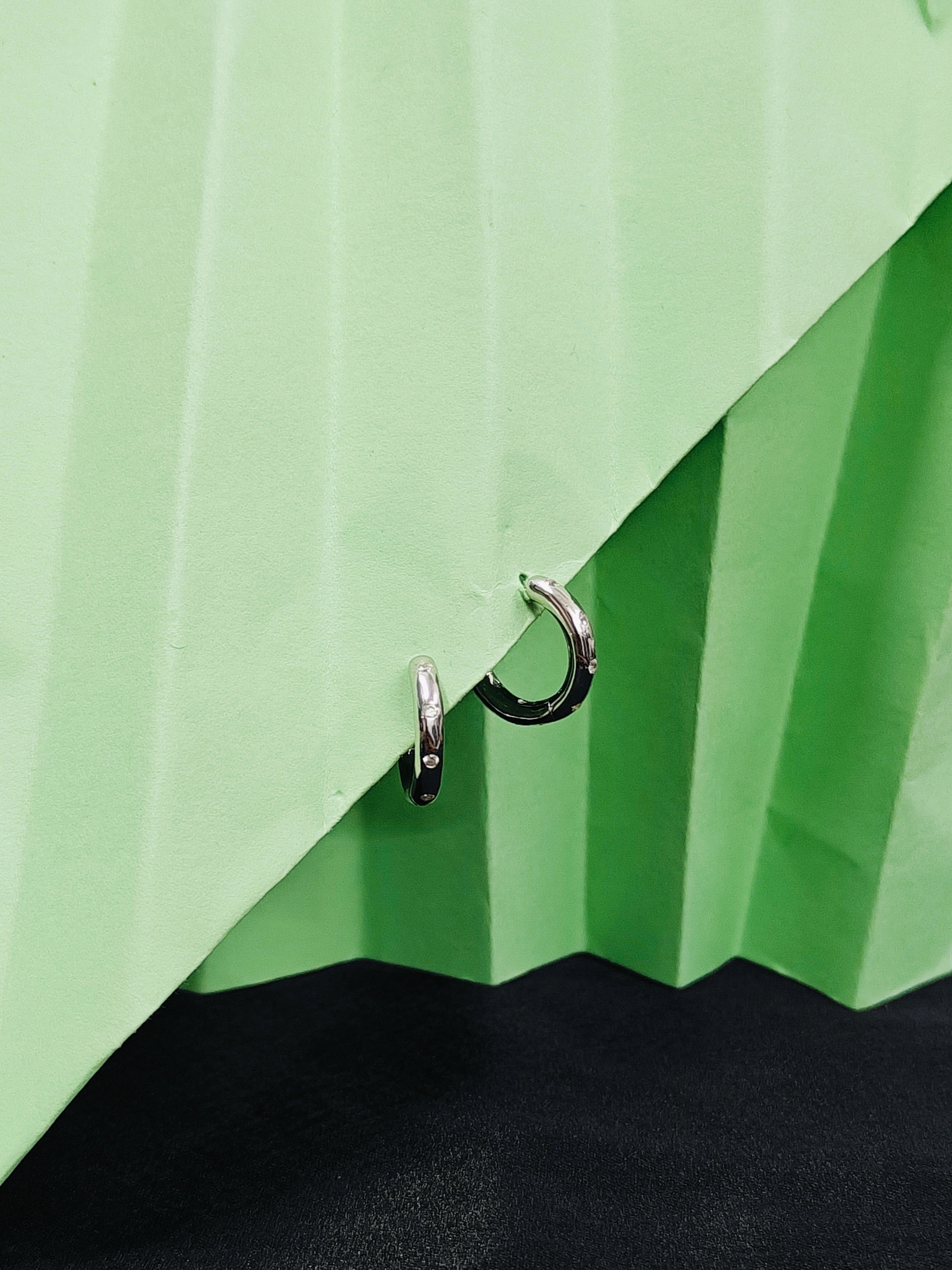 Close-up of a green umbrella with a metal clip on a black background